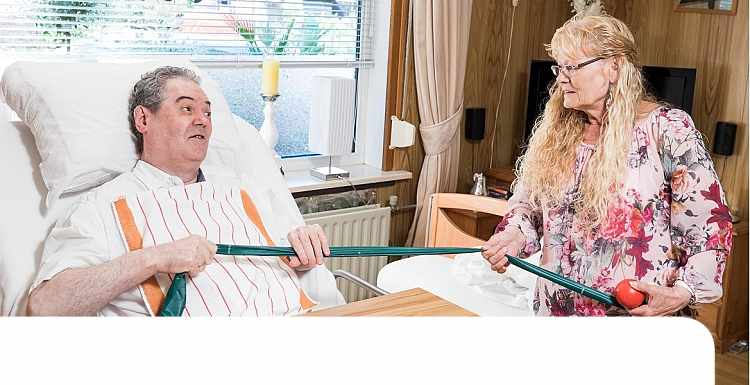 Vrouw helpt man uit bed